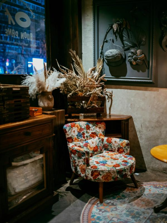 vintage chair with dried flowers beside bookshelf cozy décor